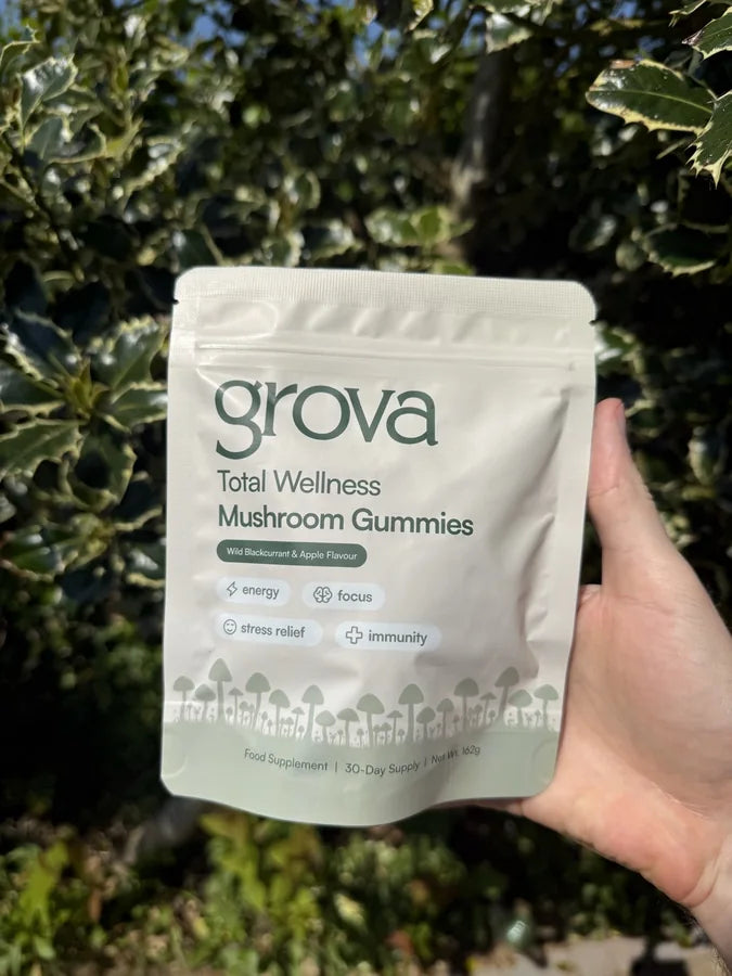 Our original Grova pouch held in front of green foliage.